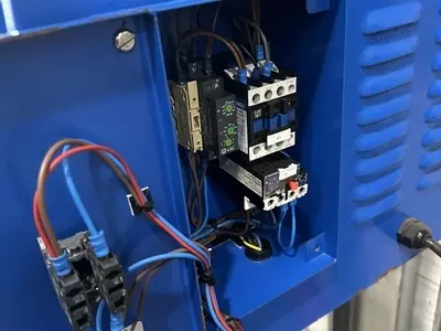 Replacement electrical contactor and overload fitted inside the control panel of a Nilfisk DTE wall-mounted pressure washer.